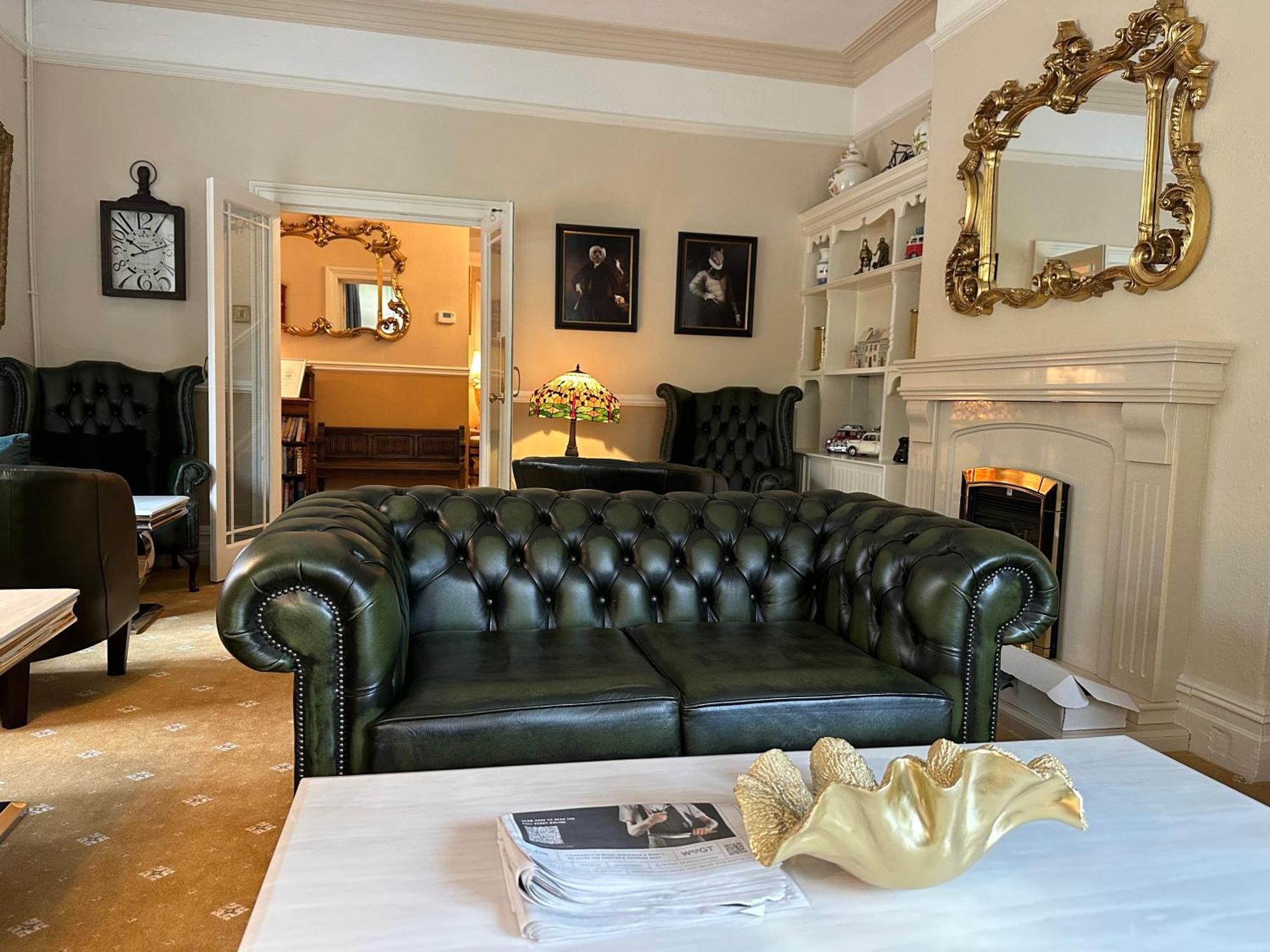 Chester House Guest House Luaran gambar A green leather Chesterfield sofa